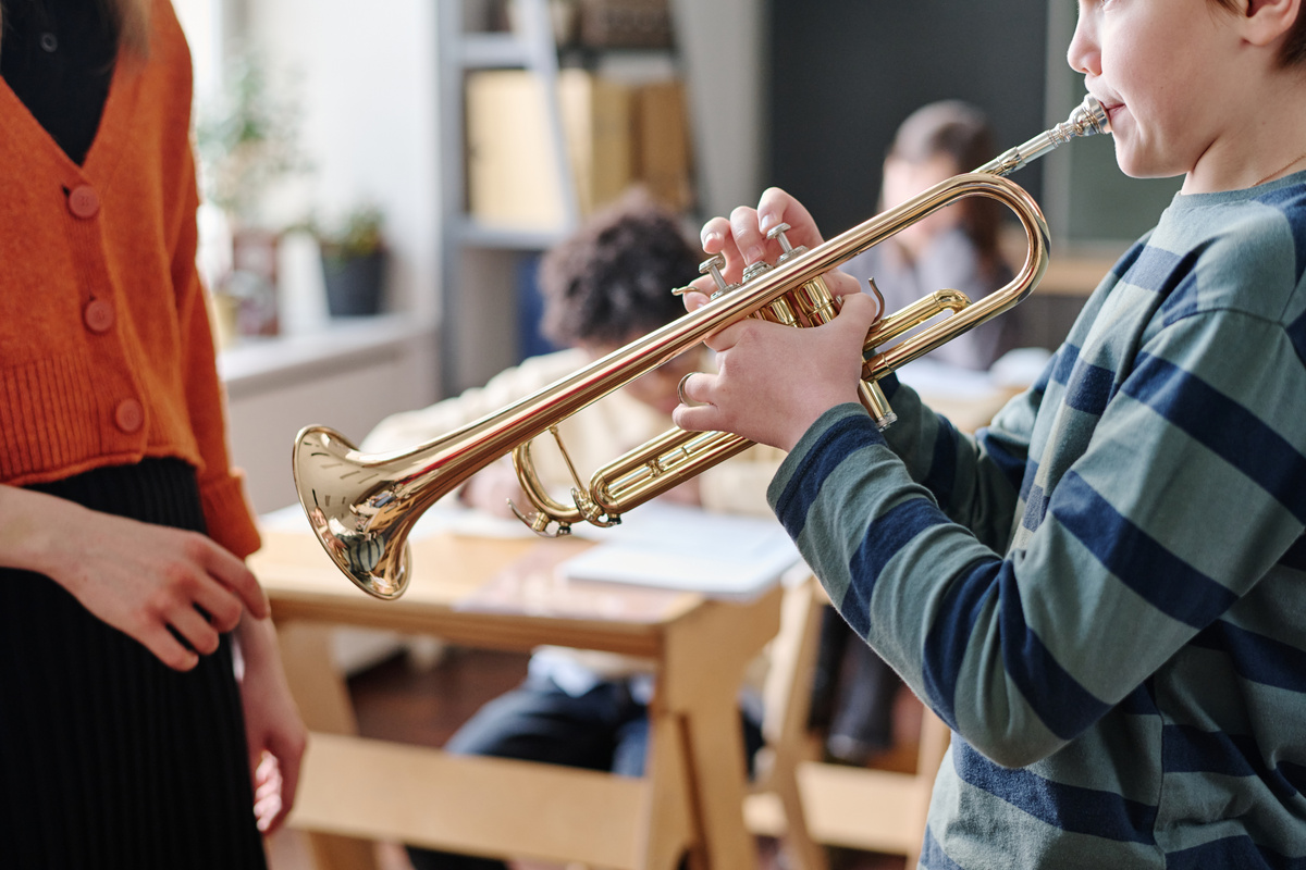 Kid Playing Brass Instrument during Music Class